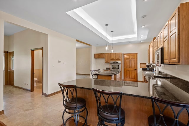 5373 Summit Rd SW, Pataskala, OH 43062 - kitchen featuring stainless steel appliances, dark countertops, a peninsula, and brown cabinetry