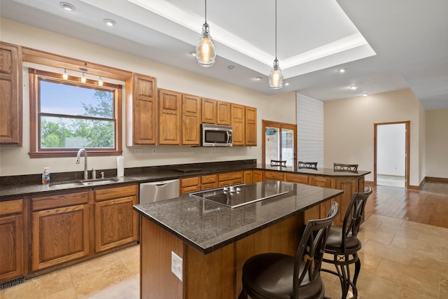 5373 Summit Rd SW, Pataskala, OH 43062 - kitchen with stainless steel appliances, brown cabinets, a kitchen bar, a peninsula, and recessed lighting