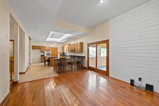 5373 Summit Rd SW, Pataskala, OH 43062 - kitchen featuring stainless steel appliances, a kitchen bar, light wood-type flooring, a peninsula, and brown cabinetry