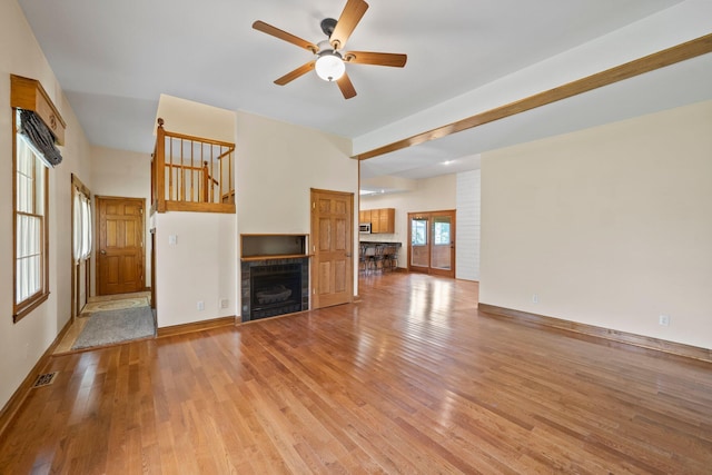 5373 Summit Rd SW, Pataskala, OH 43062 - unfurnished living room with a ceiling fan, light wood-style floors, a tile fireplace, and stairs