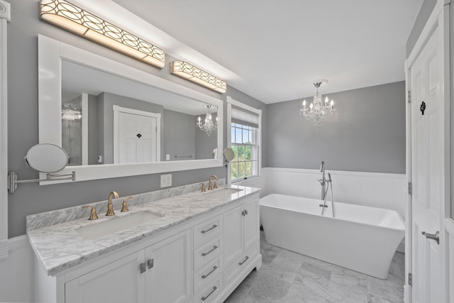 5373 Summit Rd SW, Pataskala, OH 43062 - bathroom with a chandelier, a wainscoted wall, double vanity, marble look tiles, and a freestanding bath