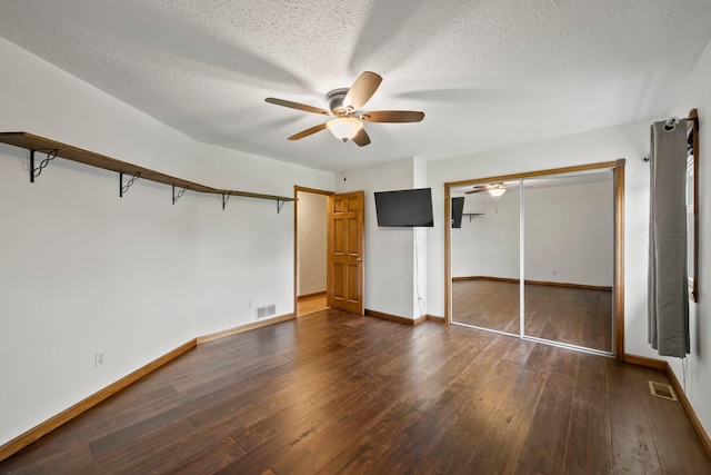 5373 Summit Rd SW, Pataskala, OH 43062 - unfurnished bedroom featuring dark wood-style floors, a textured ceiling, a ceiling fan, and a closet