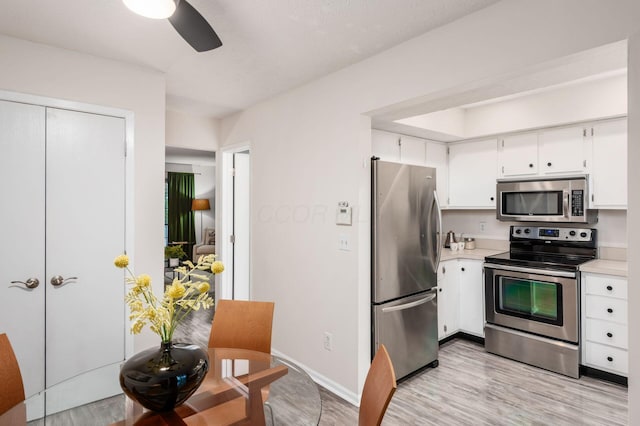 7911 Verandah Ct Unit 58, Powell, OH 43065 - kitchen featuring stainless steel appliances, light countertops, light wood finished floors, and white cabinets