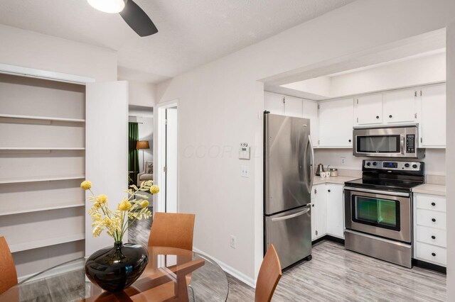 7911 Verandah Ct Unit 58, Powell, OH 43065 - kitchen featuring appliances with stainless steel finishes, light countertops, light wood-style floors, and white cabinetry
