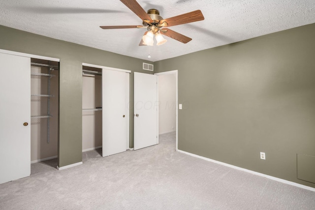 7911 Verandah Ct Unit 58, Powell, OH 43065 - unfurnished bedroom with multiple closets, light carpet, a textured ceiling, and ceiling fan