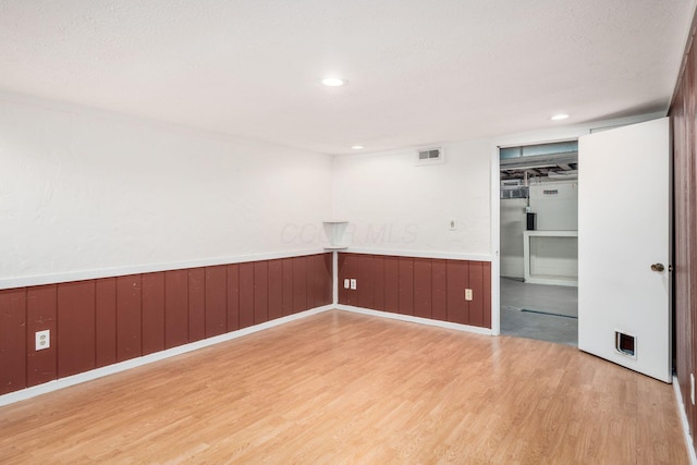 7911 Verandah Ct Unit 58, Powell, OH 43065 - empty room featuring light wood-type flooring, wainscoting, a textured ceiling, and recessed lighting