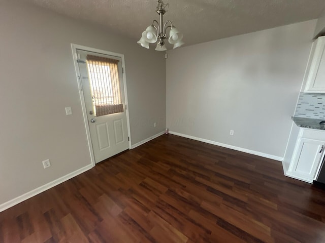 3866 Sugarbark Dr, Canal Winchester, OH 43110 - unfurnished dining area featuring a chandelier, dark wood-style flooring, and a textured ceiling