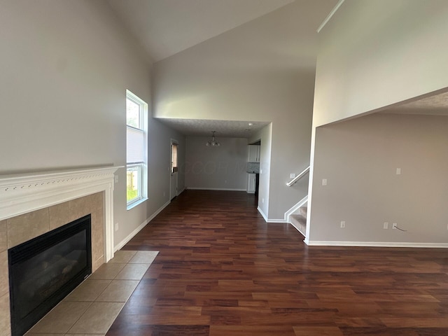 3866 Sugarbark Dr, Canal Winchester, OH 43110 - unfurnished living room featuring high vaulted ceiling, wood finished floors, a fireplace, stairway, and a chandelier