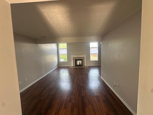 3866 Sugarbark Dr, Canal Winchester, OH 43110 - unfurnished living room with dark wood-style flooring, a tiled fireplace, and a textured ceiling