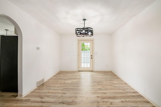 1571 Vinton Ave, Columbus, OH 43220 - unfurnished room with arched walkways, light wood-style floors, and a chandelier