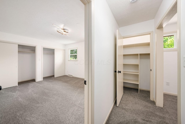 1571 Vinton Ave, Columbus, OH 43220 - unfurnished bedroom featuring carpet, two closets, and a textured ceiling