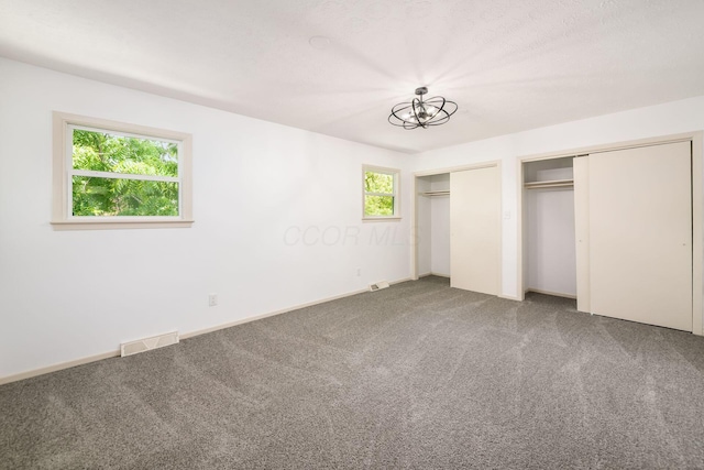 1571 Vinton Ave, Columbus, OH 43220 - unfurnished bedroom featuring two closets, carpet, and multiple windows