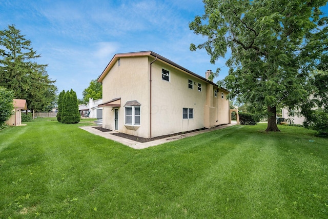 1571 Vinton Ave, Columbus, OH 43220 - rear view of property featuring a lawn, a chimney, and stucco siding