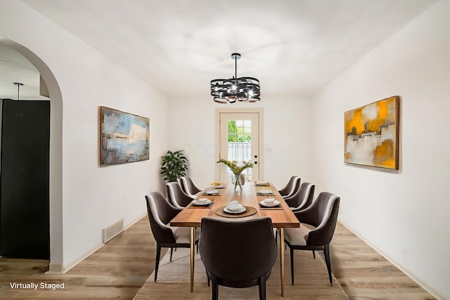 1571 Vinton Ave, Columbus, OH 43220 - dining space with arched walkways, light wood-style floors, and a chandelier