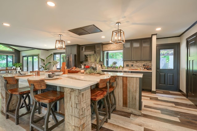 1300 Dannie Dr, Logan, OH 43138 - kitchen featuring freestanding refrigerator, decorative backsplash, a spacious island, healthy amount of natural light, and recessed lighting