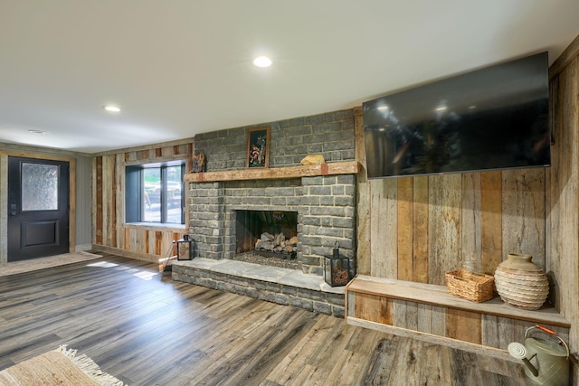 1300 Dannie Dr, Logan, OH 43138 - living area featuring wood finished floors, a brick fireplace, and wood walls
