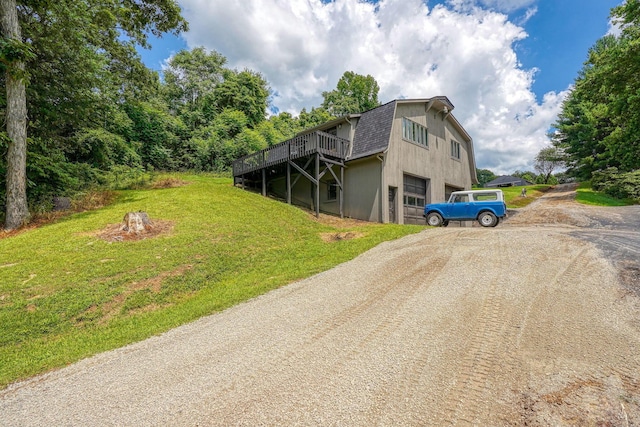 1300 Dannie Dr, Logan, OH 43138 - view of front facade with driveway, a front yard, a wooden deck, a shingled roof, and an attached garage