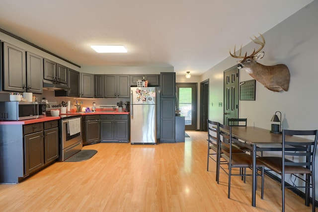 1300 Dannie Dr, Logan, OH 43138 - kitchen featuring stainless steel appliances, under cabinet range hood, and light wood-type flooring