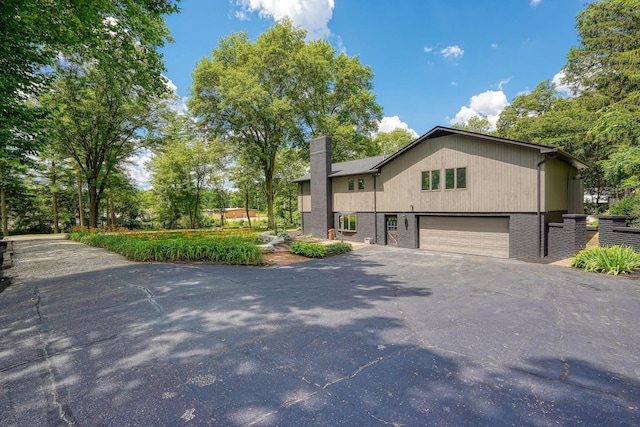 1300 Dannie Dr, Logan, OH 43138 - view of front of house featuring driveway, a chimney, and a garage