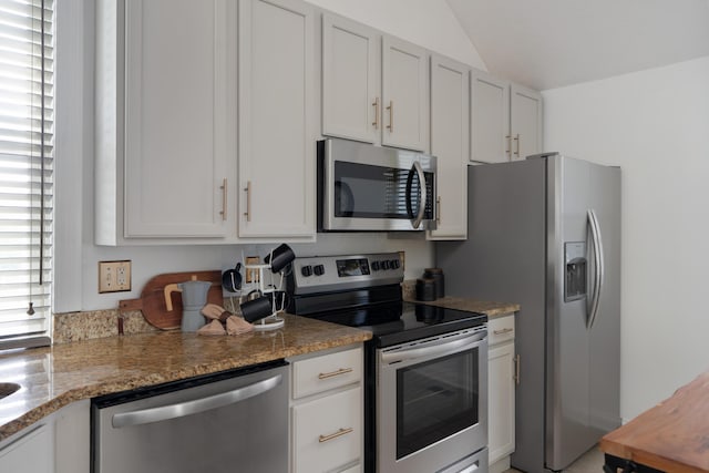 251 Detroit Ave, Columbus, OH 43201 - kitchen featuring appliances with stainless steel finishes, vaulted ceiling, white cabinets, and light stone counters
