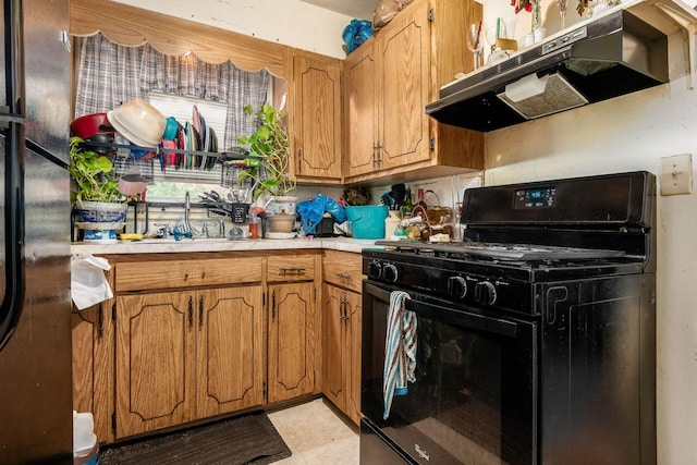 1872 Greenway Ave S, Columbus, OH 43219 - kitchen with black gas stove, under cabinet range hood, light countertops, and brown cabinetry