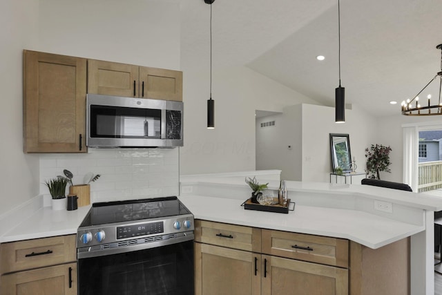 1021 Lavender Ln, Columbus, OH 43207 - kitchen with appliances with stainless steel finishes, a peninsula, backsplash, light countertops, and vaulted ceiling