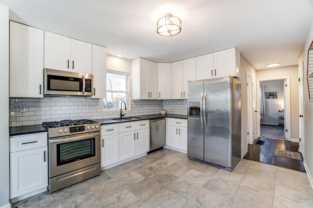 4851 Hillcrest St N, Hilliard, OH 43026 - kitchen with appliances with stainless steel finishes, dark countertops, tasteful backsplash, and white cabinetry