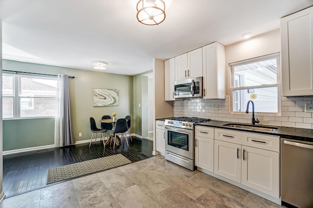 4851 Hillcrest St N, Hilliard, OH 43026 - kitchen featuring stainless steel appliances, dark countertops, tasteful backsplash, and white cabinets