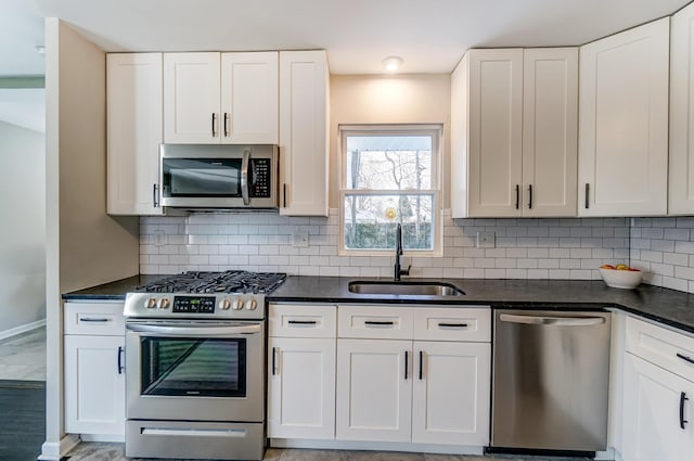 4851 Hillcrest St N, Hilliard, OH 43026 - kitchen featuring appliances with stainless steel finishes, dark countertops, and white cabinetry