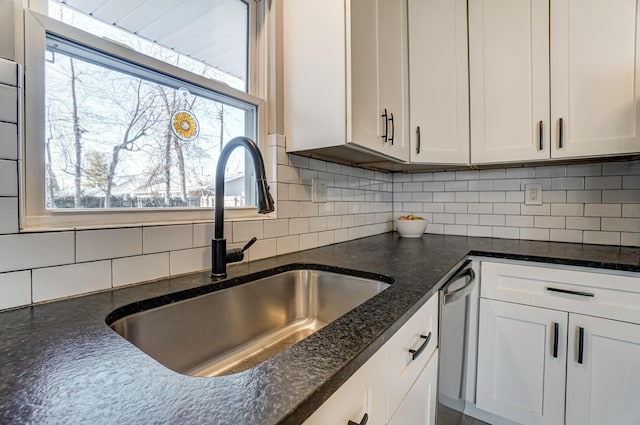 4851 Hillcrest St N, Hilliard, OH 43026 - kitchen featuring stainless steel dishwasher, decorative backsplash, white cabinets, and dark stone countertops