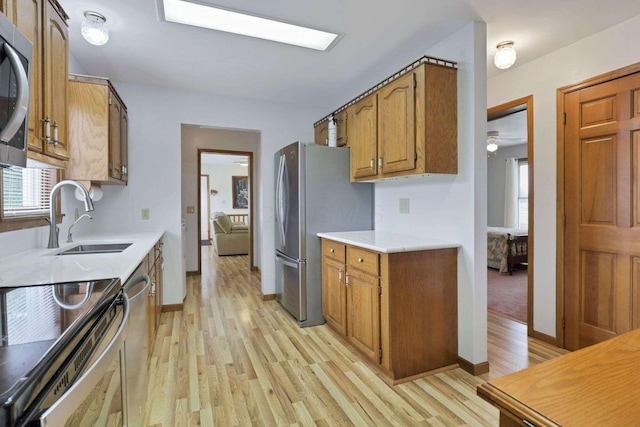 6658 Ridpath Rd, Grove City, OH 43123 - kitchen featuring stainless steel appliances, light wood-style floors, light countertops, brown cabinetry, and plenty of natural light