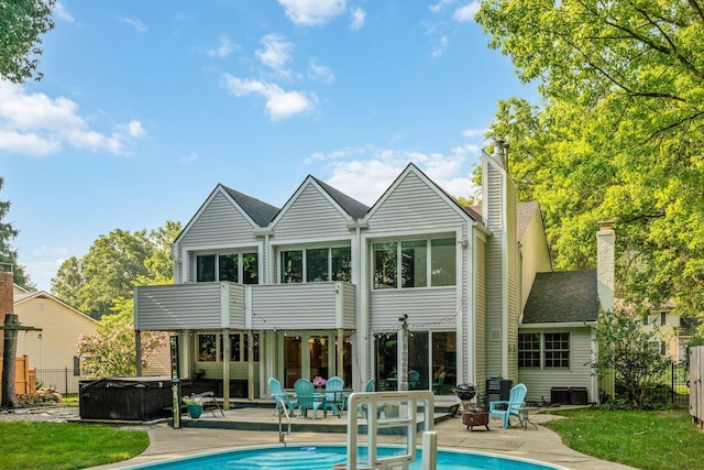 1318 Hickory Ridge Ln, Columbus, OH 43235 - back of property featuring a hot tub, a patio, an outdoor pool, and a chimney