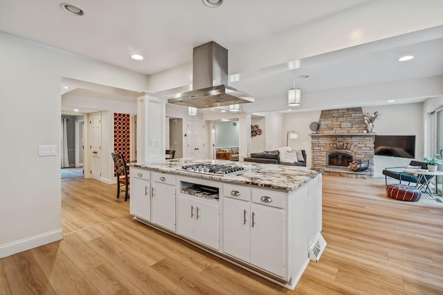 1318 Hickory Ridge Ln, Columbus, OH 43235 - kitchen with white cabinets, stainless steel gas cooktop, island range hood, light wood finished floors, and a center island