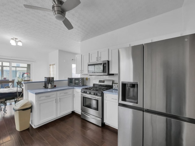 3136 Fabyan Dr, Reynoldsburg, OH 43068 - kitchen featuring appliances with stainless steel finishes, a peninsula, white cabinets, a textured ceiling, and dark wood-type flooring