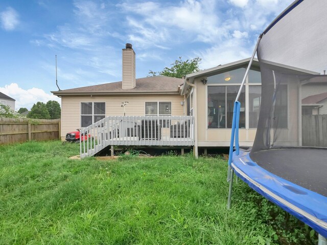 3136 Fabyan Dr, Reynoldsburg, OH 43068 - back of property featuring a trampoline, a chimney, a wooden deck, and a sunroom