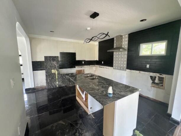 959 Kelton Ave, Columbus, OH 43206 - kitchen featuring wall chimney exhaust hood, a kitchen island, dark stone countertops, and dark marble finish flooring