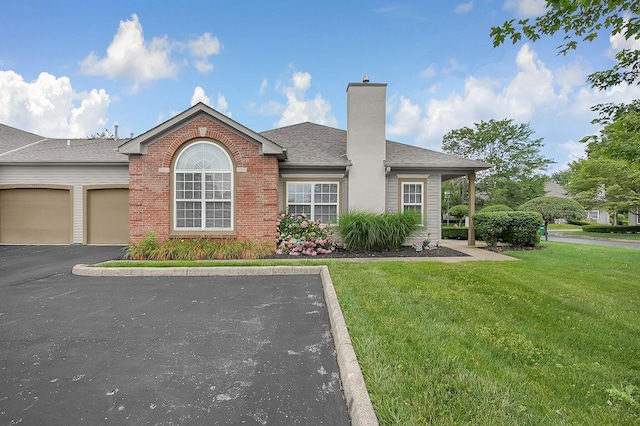 262 Alexander Lawrence Dr, Pickerington, OH 43147 - view of front of home featuring a front yard, a chimney, brick siding, an attached garage, and a shingled roof