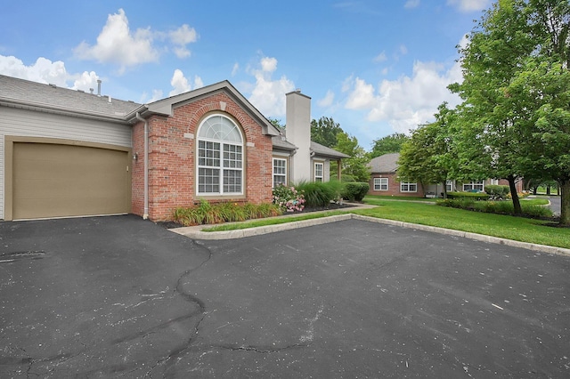262 Alexander Lawrence Dr, Pickerington, OH 43147 - view of front facade featuring driveway, brick siding, a chimney, a front lawn, and a garage