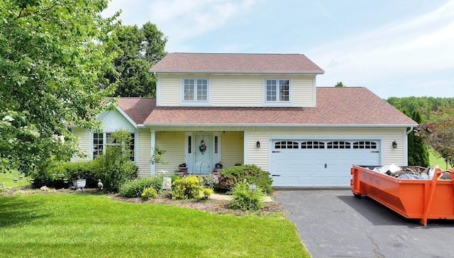 2 Delaware Dr, Fredericktown, OH 43019 - view of front of home featuring covered porch, a front yard, a garage, driveway, and a shingled roof