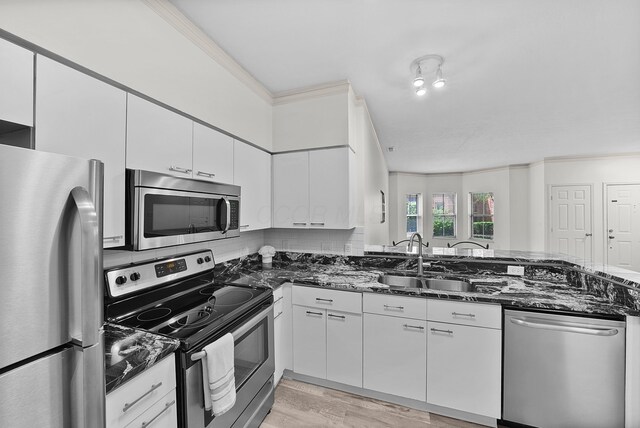 25 Victorian Gate Way, Columbus, OH 43215 - kitchen with appliances with stainless steel finishes, dark stone countertops, white cabinetry, decorative backsplash, and light wood-type flooring