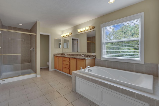7511 Windsor Dr, Dublin, OH 43016 - full bathroom featuring double vanity, a shower stall, a bath, and tile patterned floors