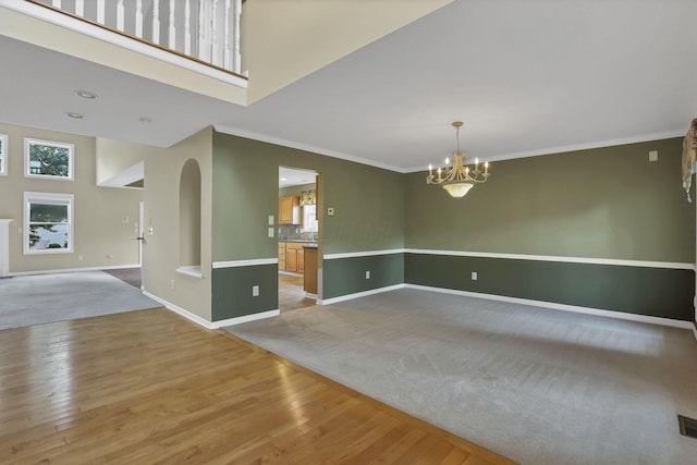 7511 Windsor Dr, Dublin, OH 43016 - spare room with plenty of natural light, ornamental molding, wood finished floors, a chandelier, and arched walkways