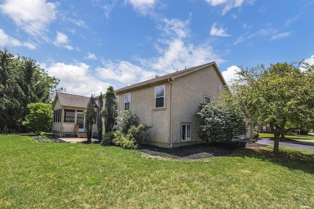 7511 Windsor Dr, Dublin, OH 43016 - rear view of property with a sunroom, a lawn, and stucco siding