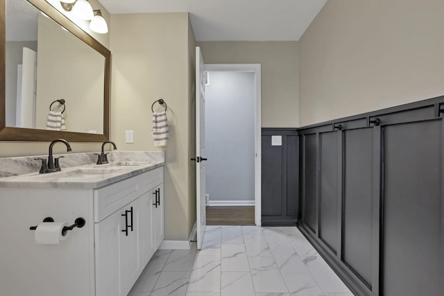 3171 Haskell Dr, Columbus, OH 43219 - bathroom featuring marble finish floors, double vanity, and a wainscoted wall