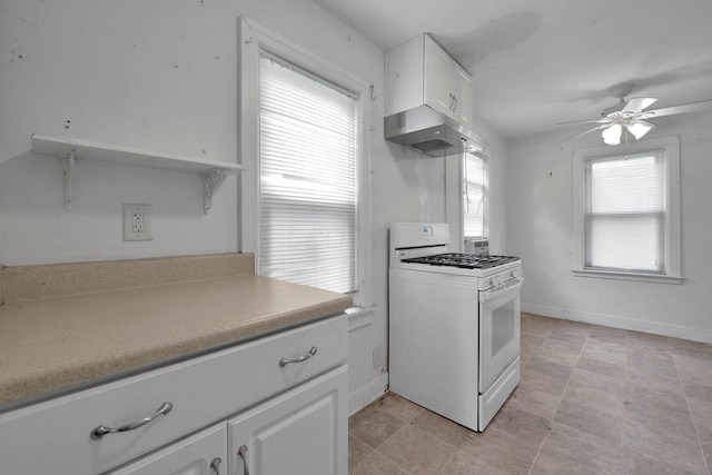 3166 Howey Rd, Columbus, OH 43224 - kitchen featuring white gas stove, wall chimney range hood, a ceiling fan, white cabinetry, and light countertops