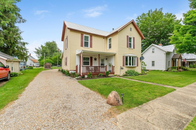 115 Maple Ave, Utica, OH 43080 - view of front facade with a porch, driveway, a front yard, and a metal roof