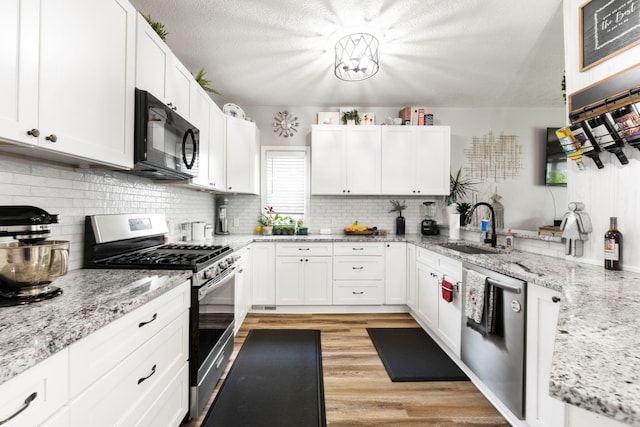 115 Maple Ave, Utica, OH 43080 - kitchen with appliances with stainless steel finishes, white cabinets, tasteful backsplash, and a textured ceiling