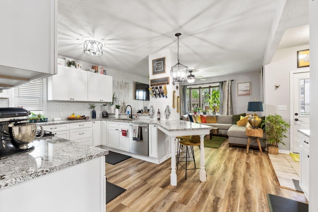 115 Maple Ave, Utica, OH 43080 - kitchen featuring stainless steel dishwasher, a peninsula, open floor plan, and light wood-style floors