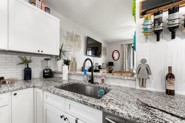 115 Maple Ave, Utica, OH 43080 - kitchen featuring backsplash, a textured ceiling, white cabinetry, and light stone counters