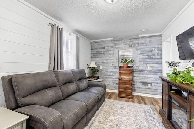 115 Maple Ave, Utica, OH 43080 - living room featuring wood finished floors, a textured ceiling, wood walls, and ornamental molding